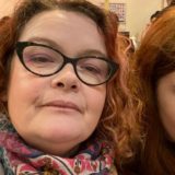 Headshot of woman wearing glasses and a patterned scarf